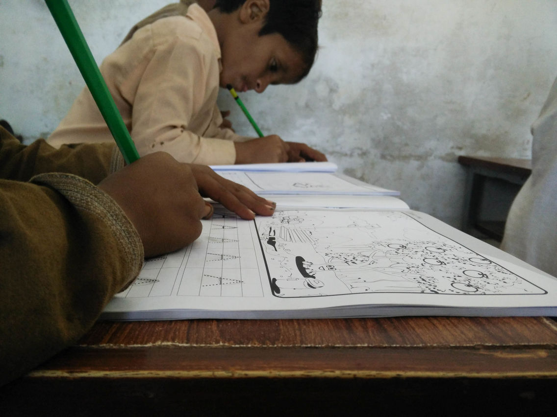 Students in Pakistan using the books that accompany Orenda's educational Taleemabad cartoon program.jpg